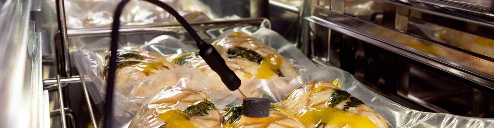 Vakuumverpackte Lebensmittel in einem Kombidämpfer für Sous-Vide-Kochen, mit einem Temperaturfühler eingesetzt.