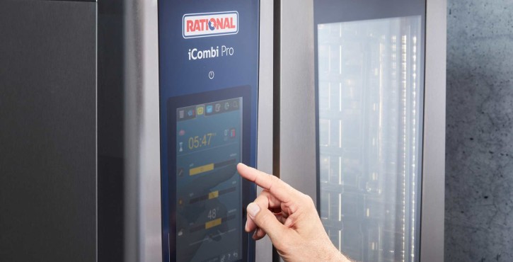 Hand interacting with touchscreen of RATIONAL iCombi Pro combi oven showing cooking program interface.
